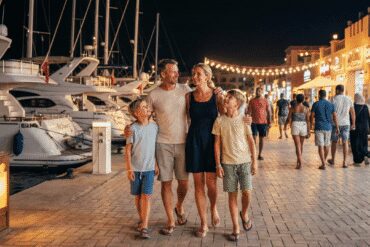 A tourist family enjoying a safe evening walk on the well-lit Hurghada Marina promenade, showcasing a secure environment.