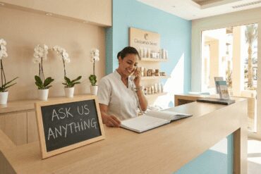 Leende receptionisten på en spa-och utflyktsdisk i Hurghada svara på frågor, som representerar vanliga frågor om spa-etikett och bokning.